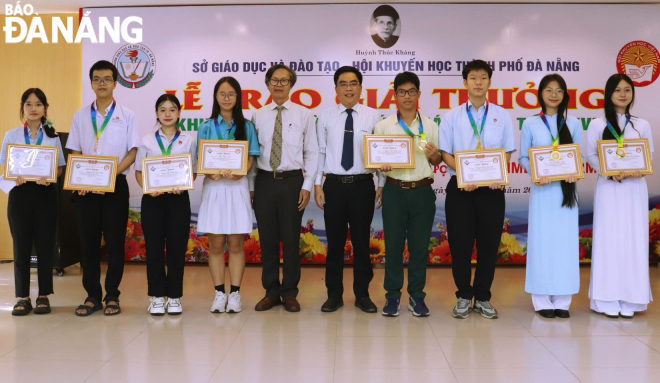 Representatives of businesses and the city's Study Encouragement Association presenting awards to those who won first prizes at the competition for junior high school pupils. Photo: NGOC HA