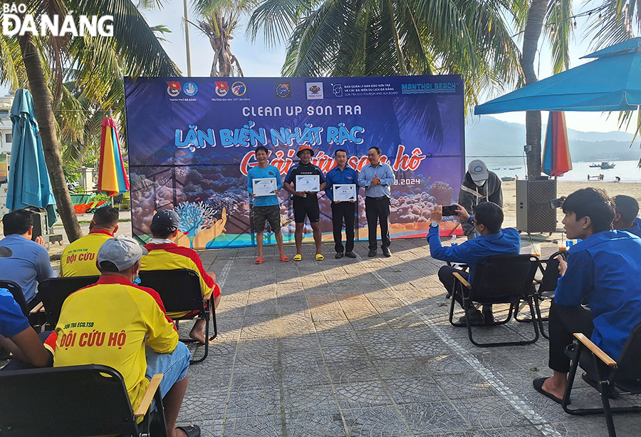 Deputy Head of the Authority of the Son Tra Peninsula and Da Nang Tourist Beaches Phan Minh Hai awarding Certificates of Merit to associations, unions and clubs participating in the campaign. Photo: THU HA