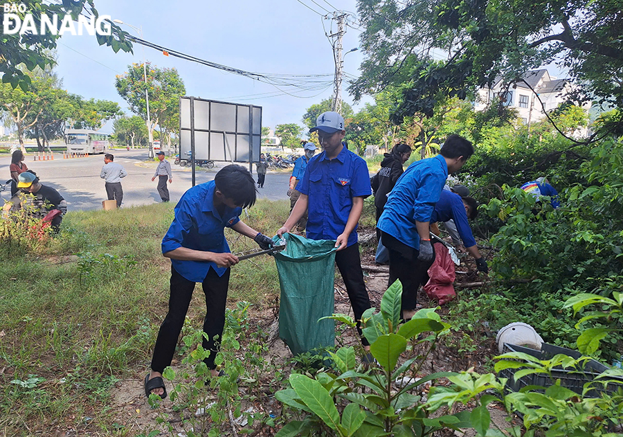 Volunteers and youth union members collecting trash on Le Van Luong - Ho Xanh route. Photo: THU HA