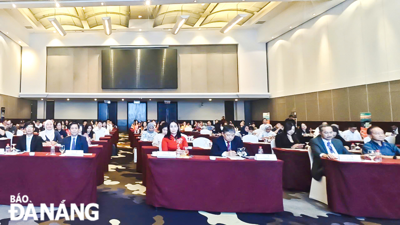 Vice Chairwoman of the Da Nang People's Committee Nguyen Thi Anh Thi (left, middle row) and delegates attending the programme.