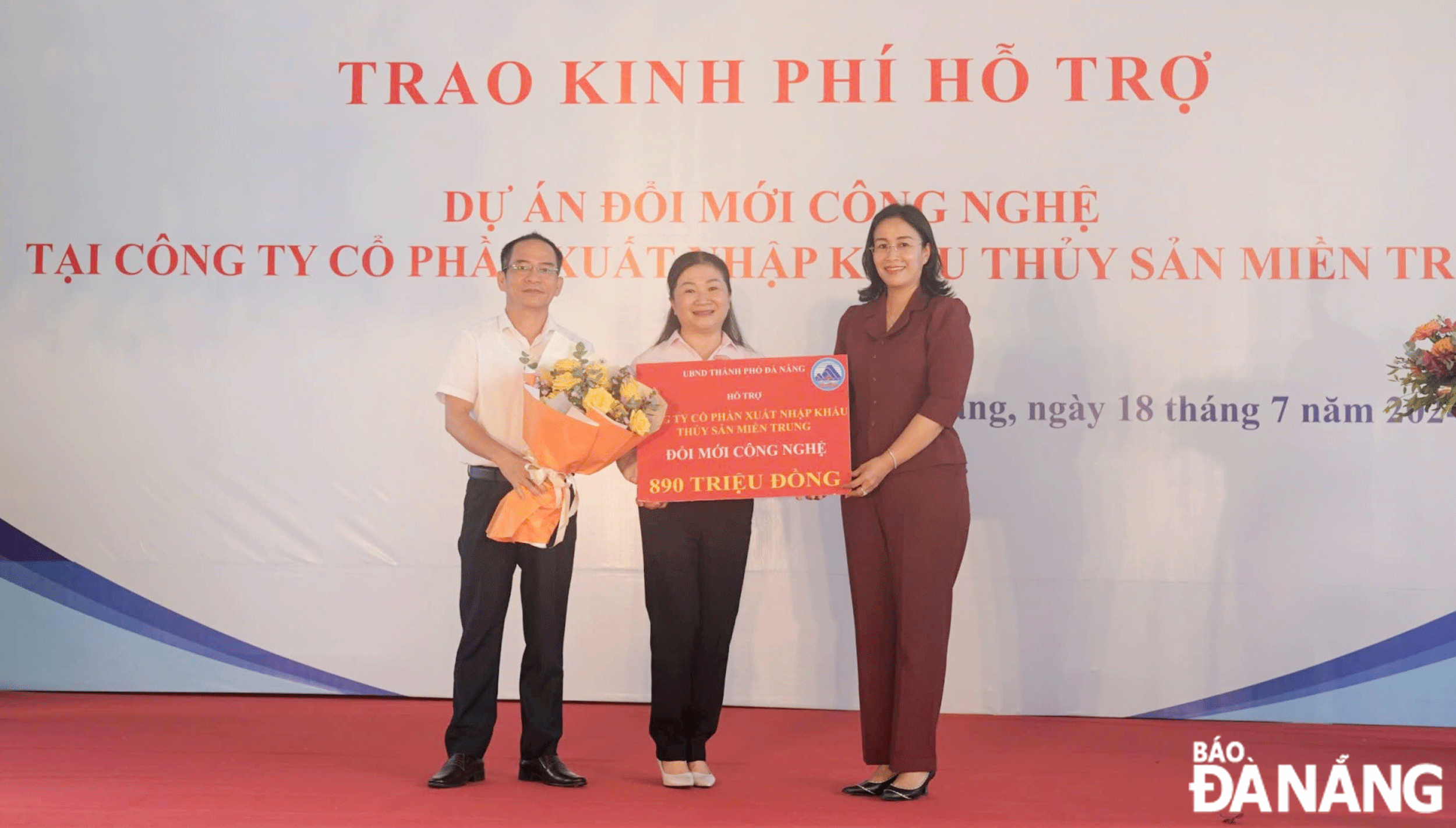 Phó Chủ tịch UBND thành phố Nguyễn Thị Anh Thi (bên phải) trao kinh phí hỗ trợ cho Công ty CP Xuất nhập khẩu thủy sản miền Trung. Ảnh: T.THẢO	