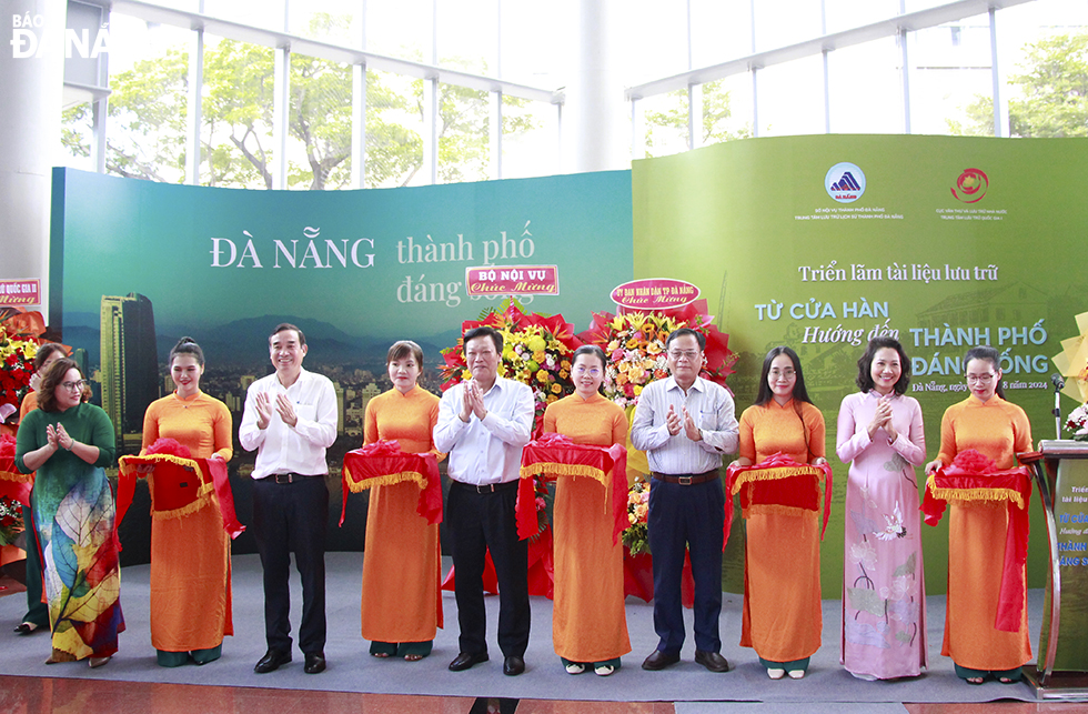 Deputy Minister of Home Affairs Nguyen Duy Thang (middle), Chairman of the municipal People's Committee Le Trung Chinh (4th, left), and delegates cutting the ribbon to open the exhibition.