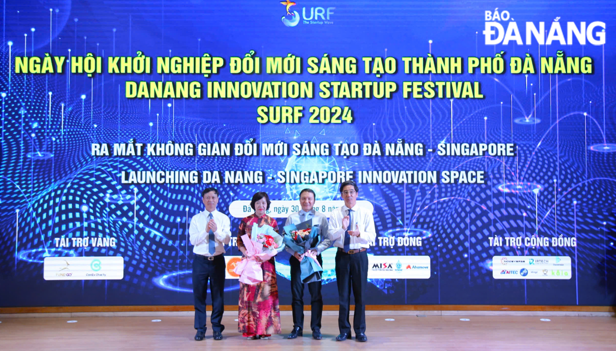 Deputy Minister of Science and Technology Hoang Minh (left) and Da Nang People's Committee Vice Chairman Tran Chi Cuong (right) presenting flowers to congratulate the launch of the Da Nang - Singapore Innovation Space.