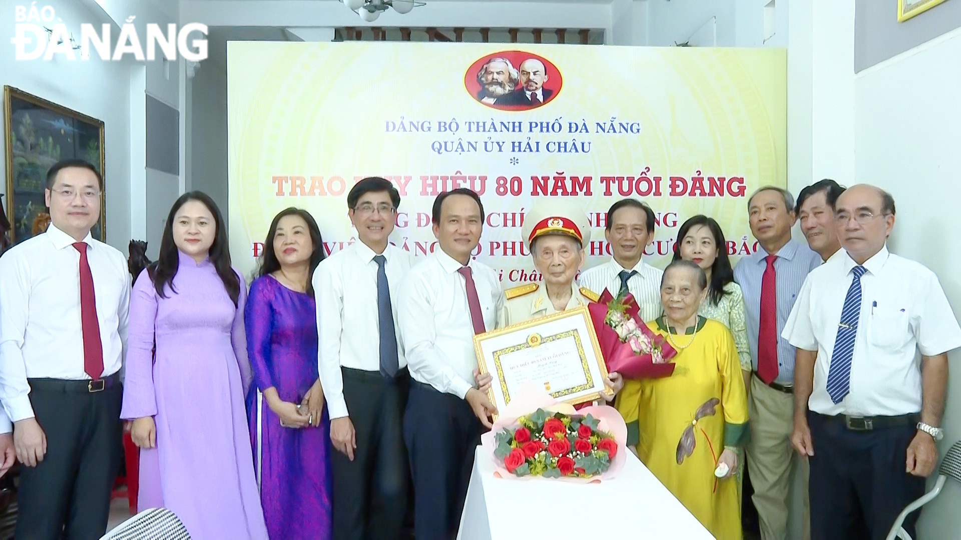 Phó Bí thư Thường trực Thành ủy Nguyễn Đình Vĩnh (thứ 5, trái sang) trao Huy hiệu 80 năm tuổi Đảng cho ông Hàng. Ảnh: QUÂN HẢI