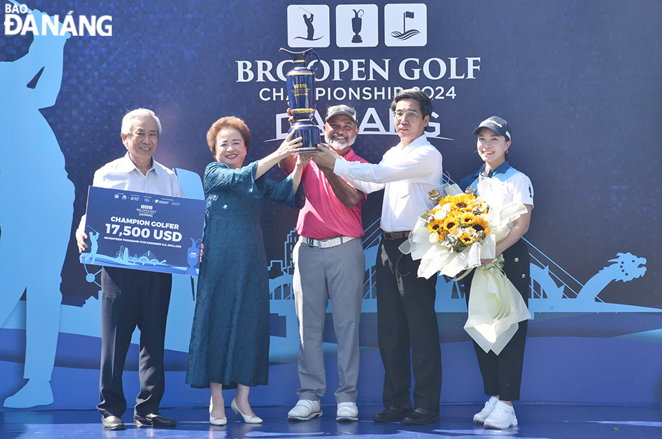 Vice Chairman of the Da NangPeople's Committee Tran Chi Cuong (second from right) and Mrs. Nguyen Thi Nga, Chairwoman of the Board of Directors of the BRG Group (second from left) presenting the cup to this year's champion. Photo: THU HA