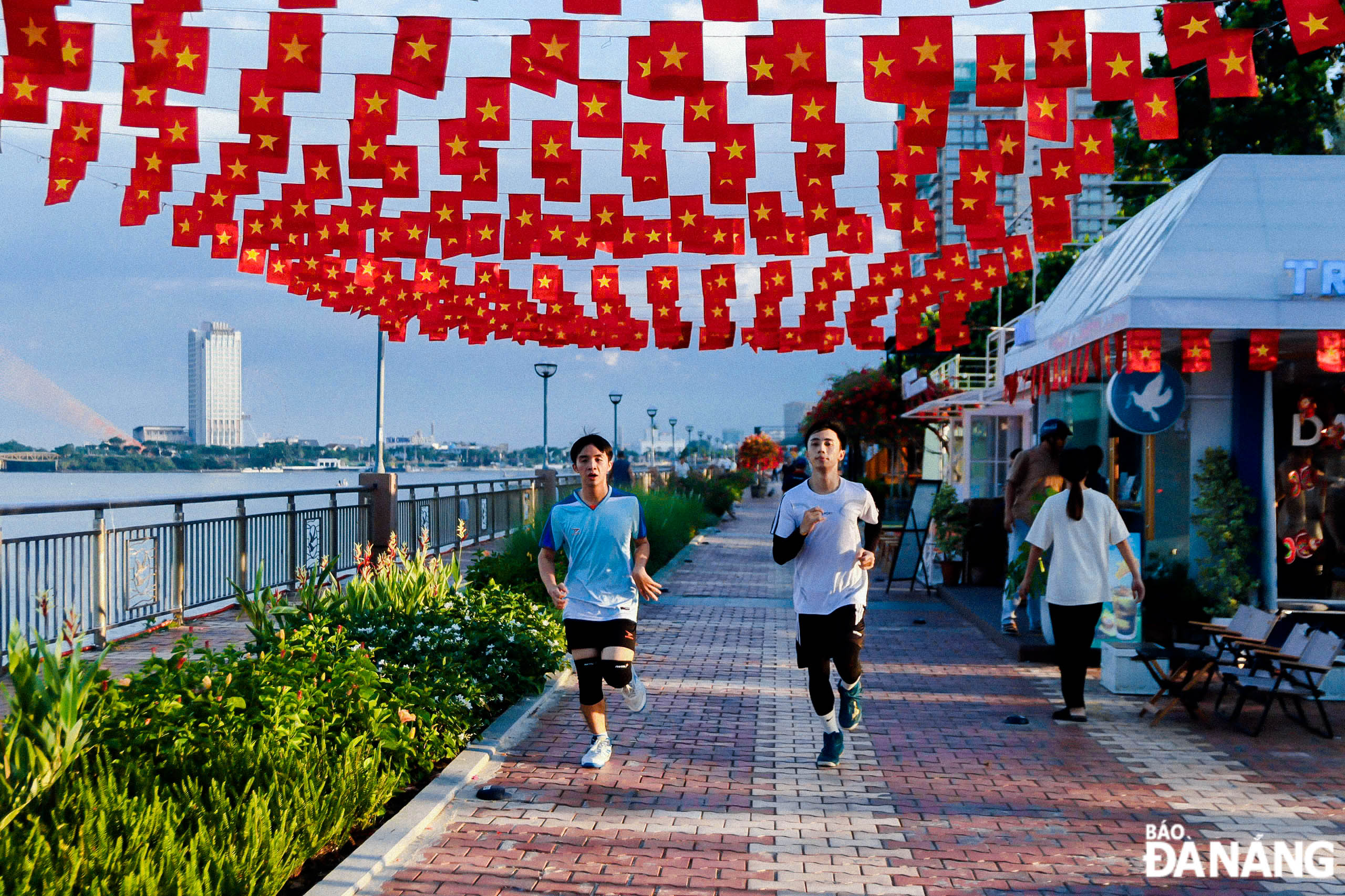 Many cafes along the Bach Dang walking street hang flags and flowers to celebrate the 79th anniversary of the August Revolution and National Day September 2 (1945-2024).