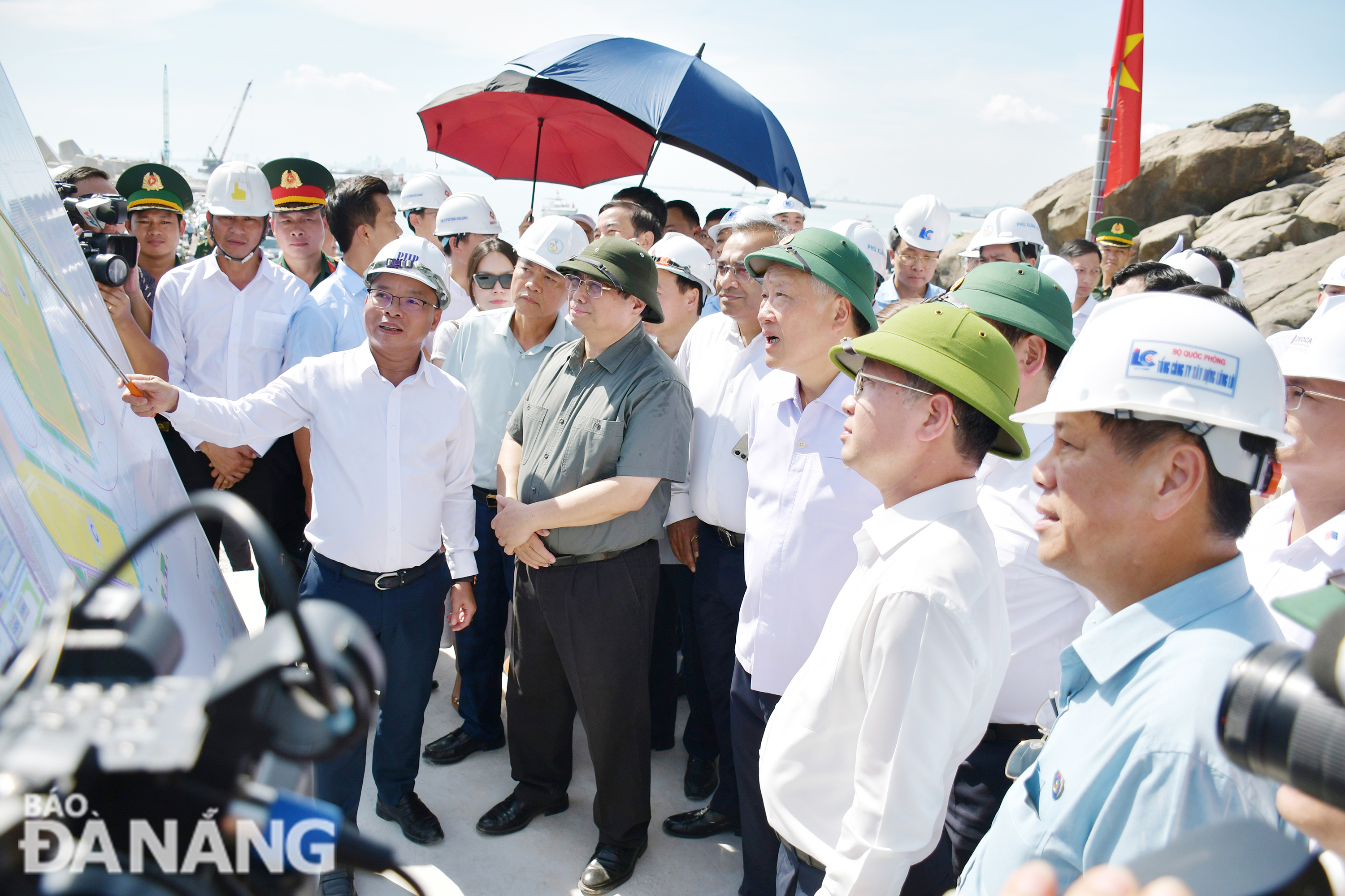 Thủ tướng Chính phủ Phạm Minh Chính (thứ 2 từ trái sang), nghe Giám đốc Ban quản lý các dự án đầu tư cơ sở hạ tầng ưu tiên thành phố Lê Thành Hưng báo cáo tiến độ dự án. Ảnh: THÀNH LÂN