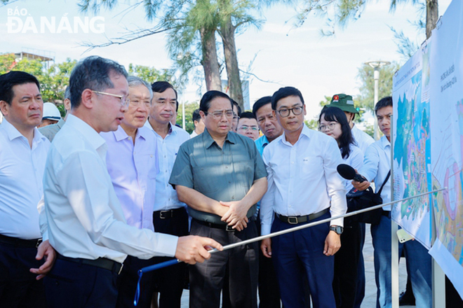 Prime Minister Pham Minh Chinh listened to Secretary of the Da Nang Party Committee Nguyen Van Quang report on the project on sea reclamation to serve the vuilding of a free trade service zone. Photo: THANH LAN