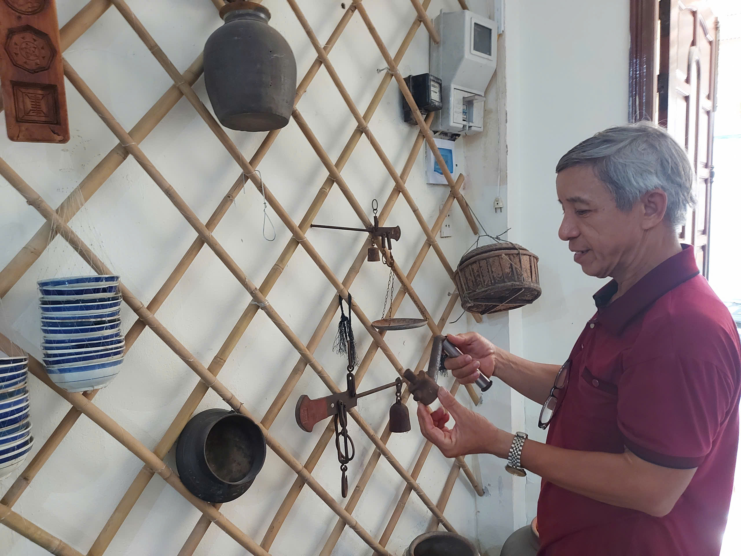 Mr. Huynh Van Muoi introduces the types of fishing gear that are being stored and displayed in his house. Photo: D.H.L