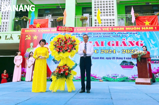 Trưởng Ban Tuyên giáo Thành ủy Đoàn Ngọc Hùng Anh (bên phải) tặng hoa chúc mừng thầy và trò Trường Tiểu học Hoa Lư. Ảnh: NGỌC HÀ