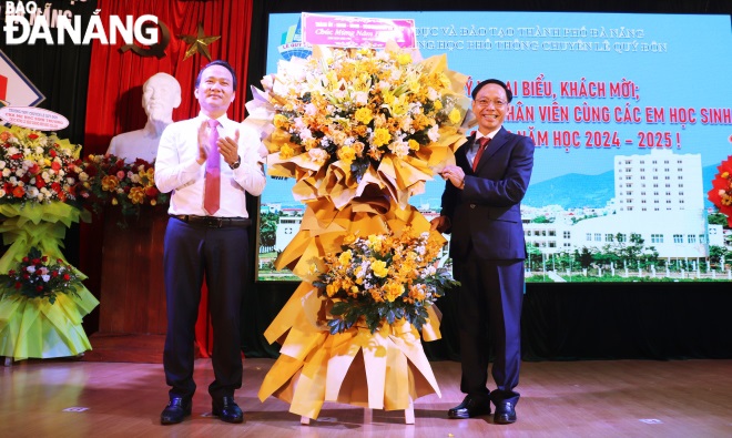 Standing Deputy Secretary of the municipal Party Committee Nguyen Dinh Vinh (left) congratulating the Le Quy Don Senior High School for the Gifted on the occasion of the new academic year. Photo: NGOC HA