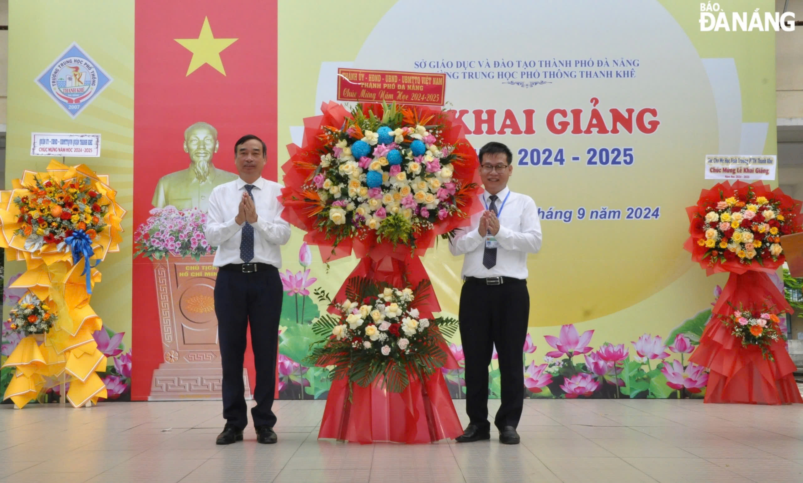 Chairman of the municipal People's Committee Le Trung Chinh (left) presenting flowers to congratulate the Thanh Khe Senior High School. Photo: LE HUNG