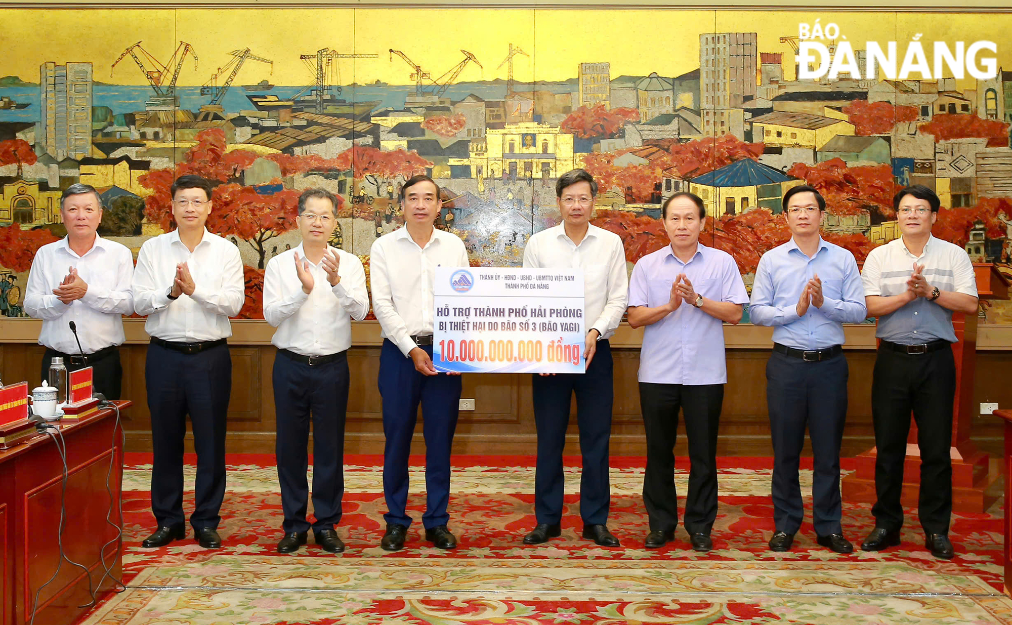 Secretary of the Da Nang Party Committee Nguyen Van Quang (3rd from left), Chairman of the municipal People's Committee Le Trung Chinh (4th from left) and representatives of the working delegation giving a symbolic board of donations worth VND 10 billion to Hai Phong on the morning of September 10. 