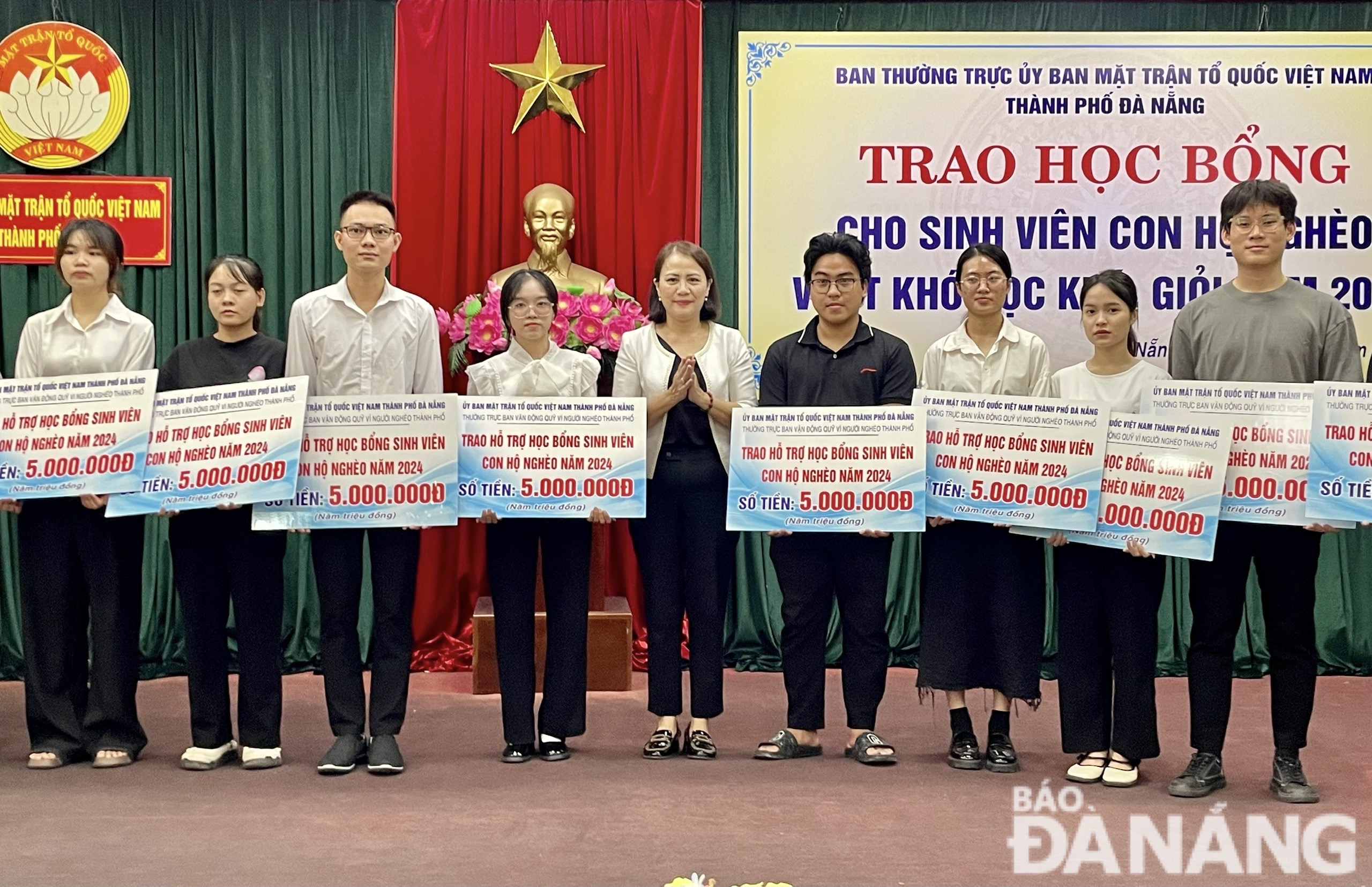 Vice President of the Viet Nam Fatherland Front Committee of Da Nang Tran Thi Man (middle) presenting scholarships to students. Photo: N.QUANG