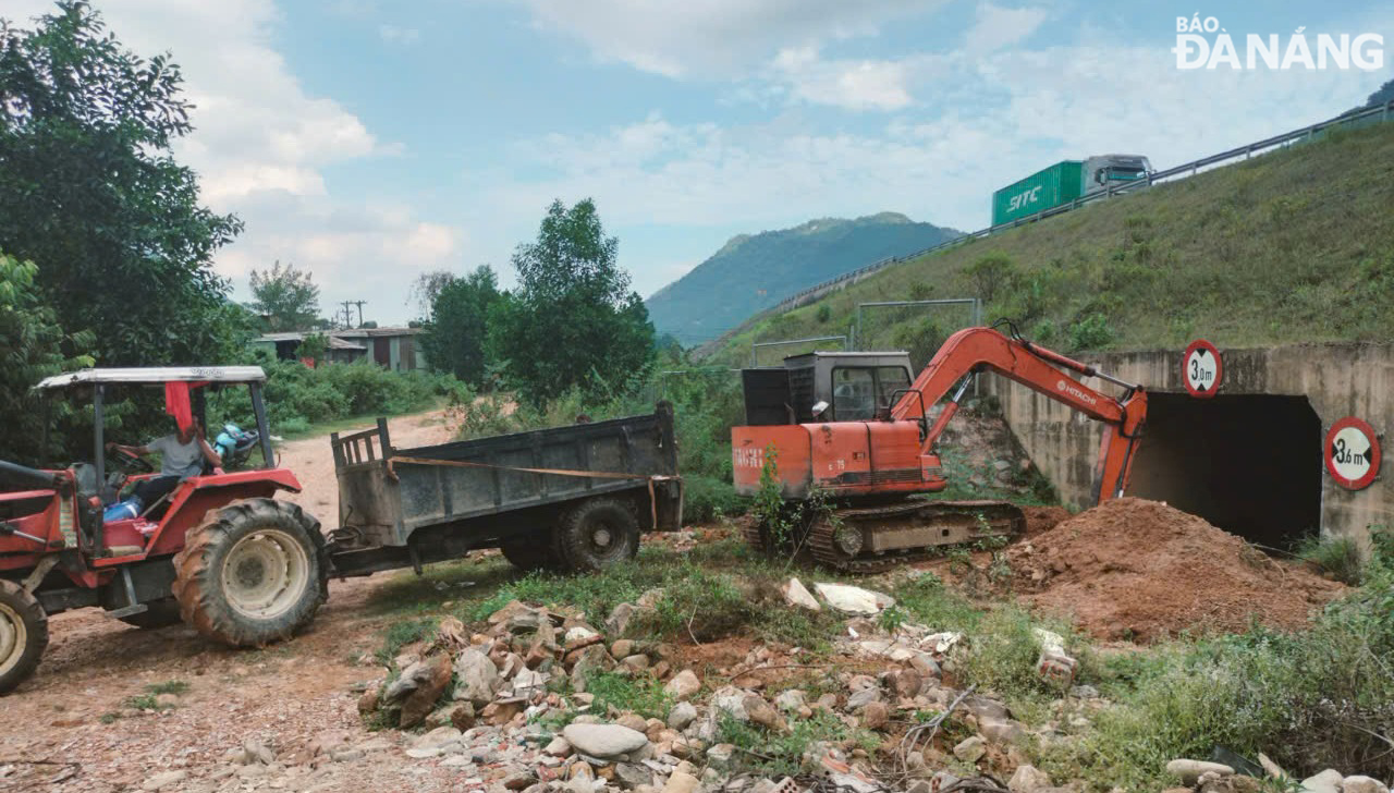 Bùn đất trong cống qua đường cao tốc Đà Nẵng - Quảng Ngãi đang được nạo vét. Ảnh: H.H