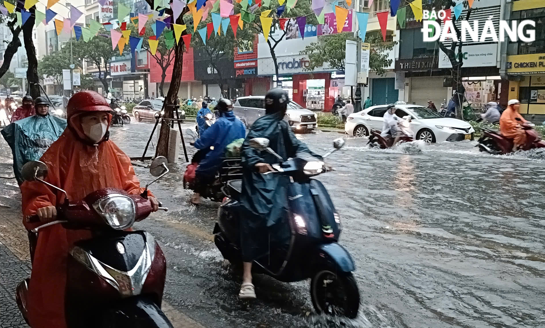 Nhiều người dân phải di chuyển phương tiện lên lề đường để lưu thông do ngập lụt cục bộ