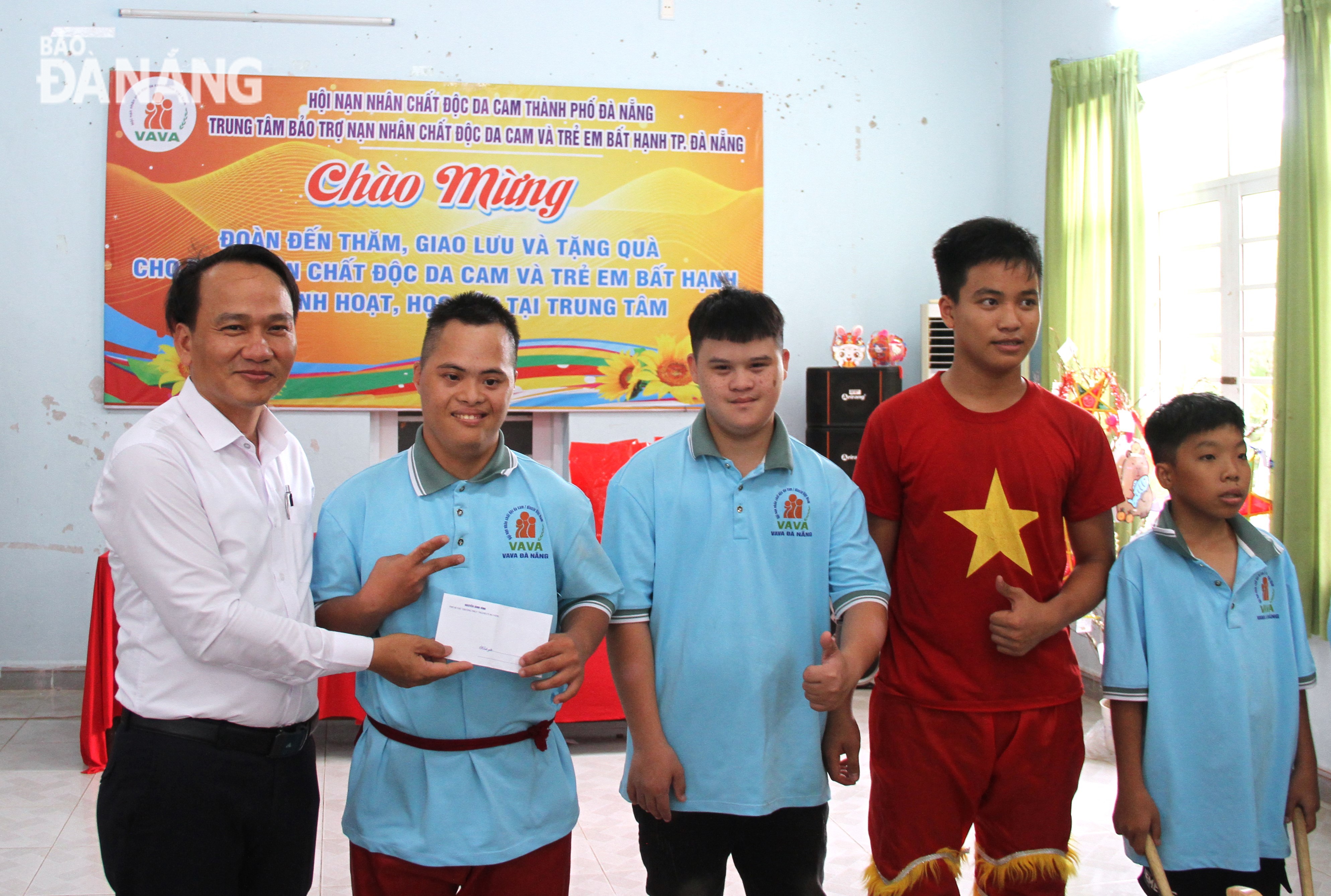 Permanent Deputy Secretary of the municipal Party Committee Nguyen Dinh Vinh (left) presenting gifts to the lion dance troupe of children at the Da Nang Care Centre for Victims of Agent Orange (AO) and Disadvantaged Children. Photo: L.P