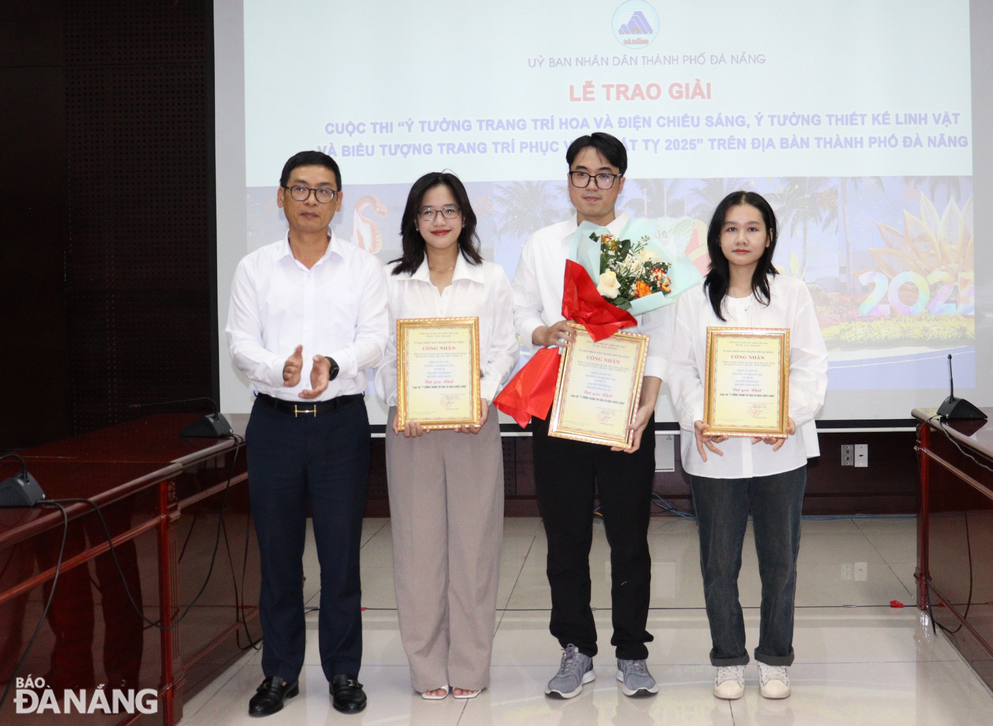 Director of the municipal Department of Construction Phung Phu Phong (first, left) giving the award to the group of authors who won the first prize for their ideas on floral display and lighting decorations for the forthcoming Lunar New Year 2025. Photo: HOANG HIEP