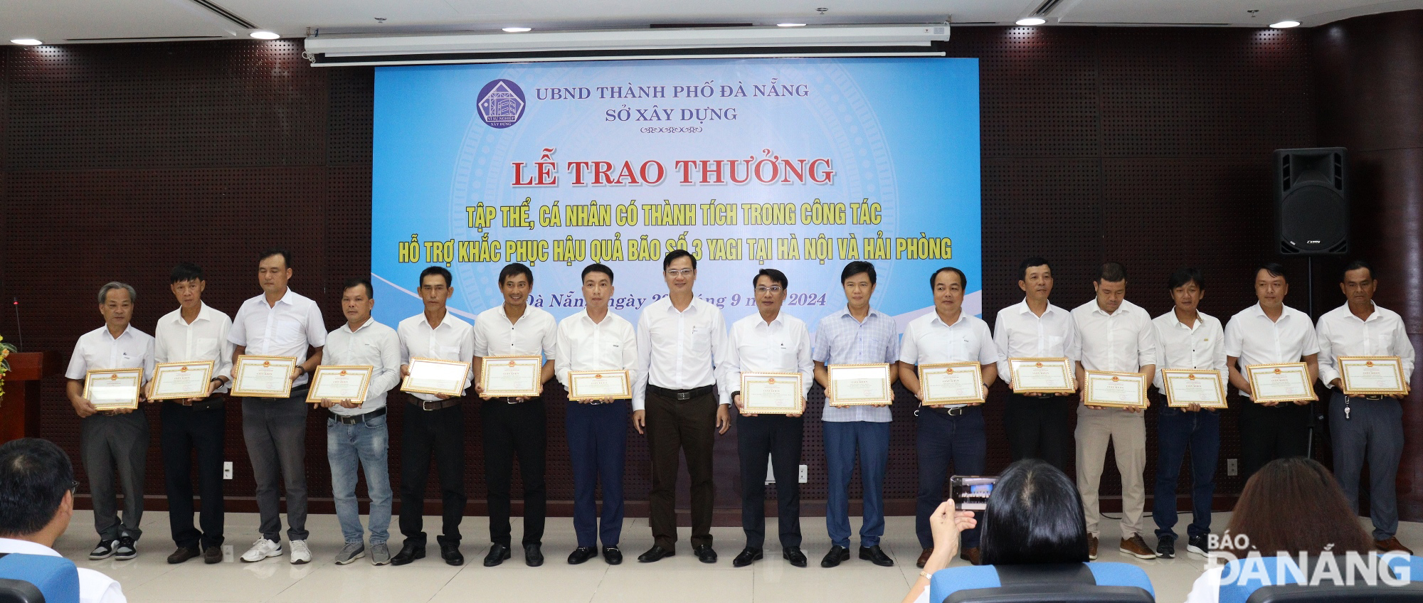 Deputy Director of the Da Nang Department of Construction Le Van Tuan (8th, left) giving Certificates of Merit to individuals in recognition of their active involvement in supporting Ha Noi and Hai Phong in overcoming the consequences of storm No. 3. Photo: HOANG HIEP