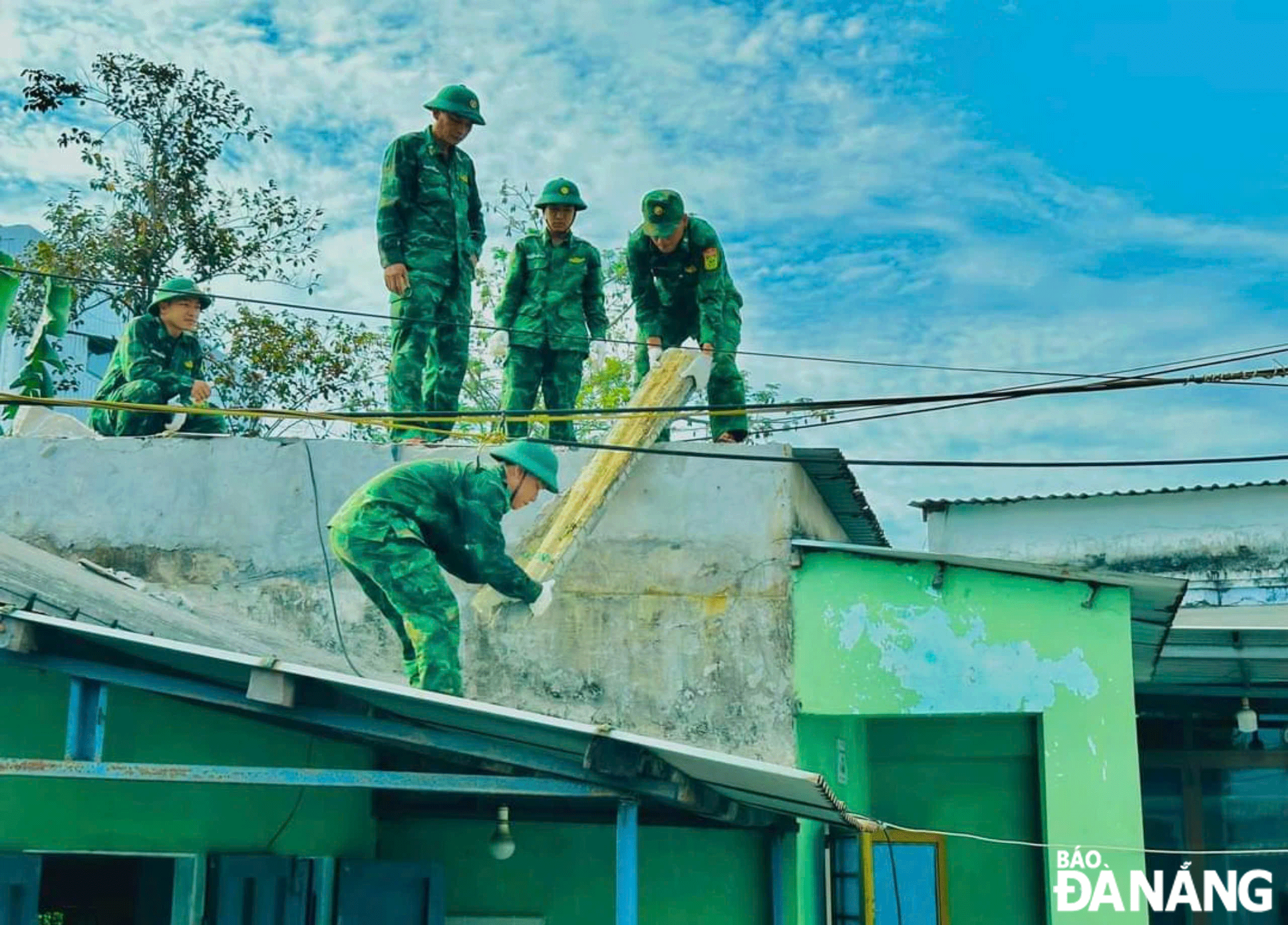 Cán bộ, chiến sĩ Đồn Biên phòng Hải Vân tham gia sửa chữa nhà cho mẹ Lê Thị Tuôi (phường Hòa Hiệp Bắc, quận Liên Chiểu). Ảnh: KIM NGÂN