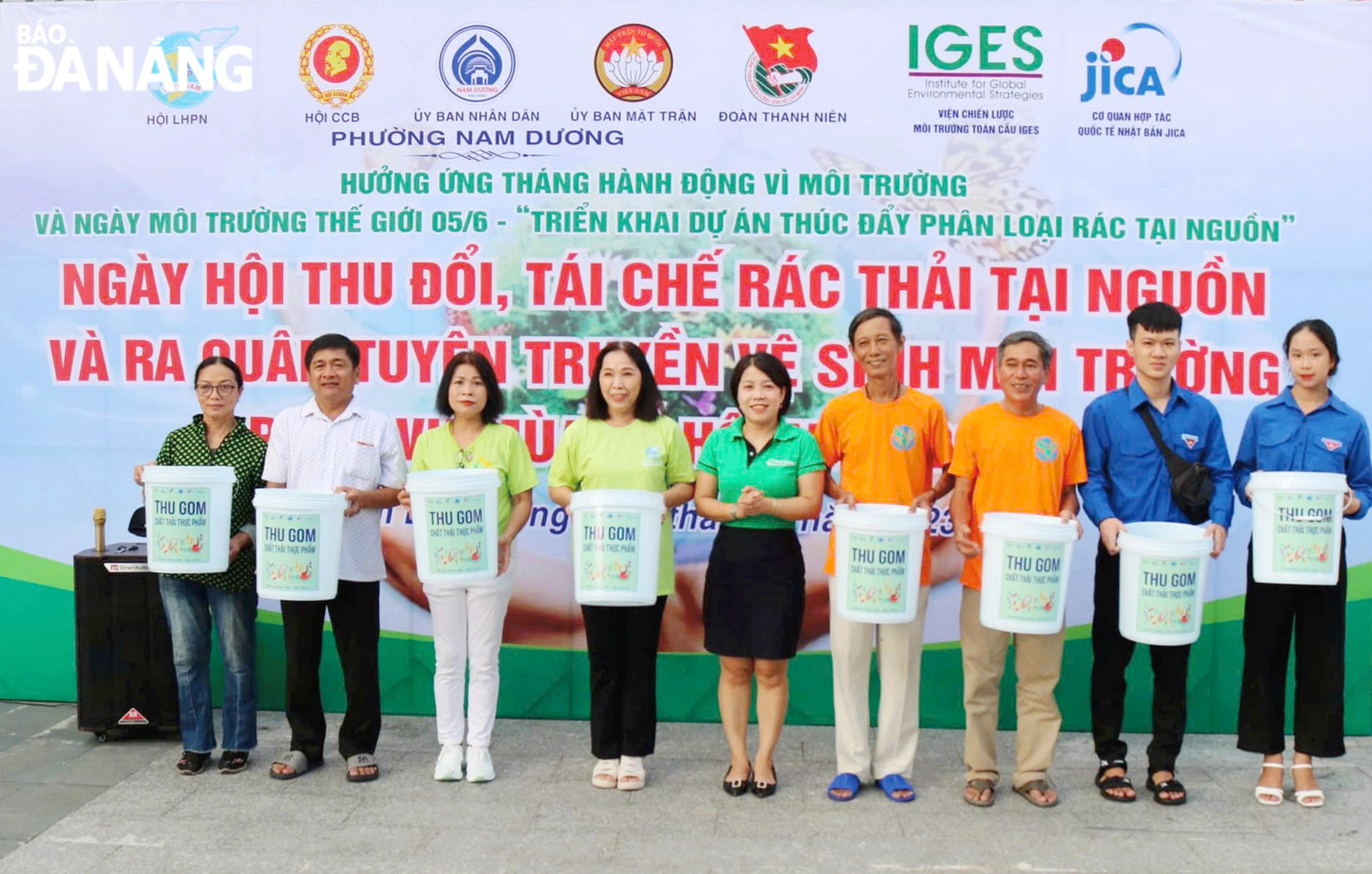 Chị Dương Thị Kiều Trinh (giữa) trao 100 thùng rác môi trường cho các hộ gia đình hưởng ứng Tháng hành động vì môi trường và ngày Môi trường thế giới. Ảnh: X.D	