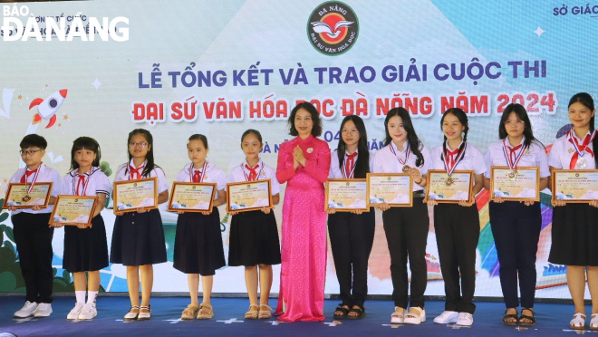 Phó giám đốc Sở Văn hóa, Thể thao thành phố Đà Nẵng Nguyễn Thị Hội An trao Giải “Văn hóa đọc Đà Nẵng” năm 2024 cho các em học sinh đoạt giải Văn hóa đọc. Ảnh: NGỌC HÀ