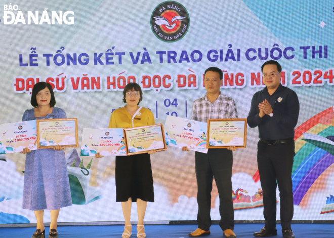 Phó Giám đốc Sở Giáo dục và Đào tạo Trần Nguyễn Minh Thành trao Giải thưởng là một tủ sách trị giá 5 triệu đồng dành cho các “Trường có nhiều thí sinh đạt giải nhất”. Ảnh: NGỌC HÀ