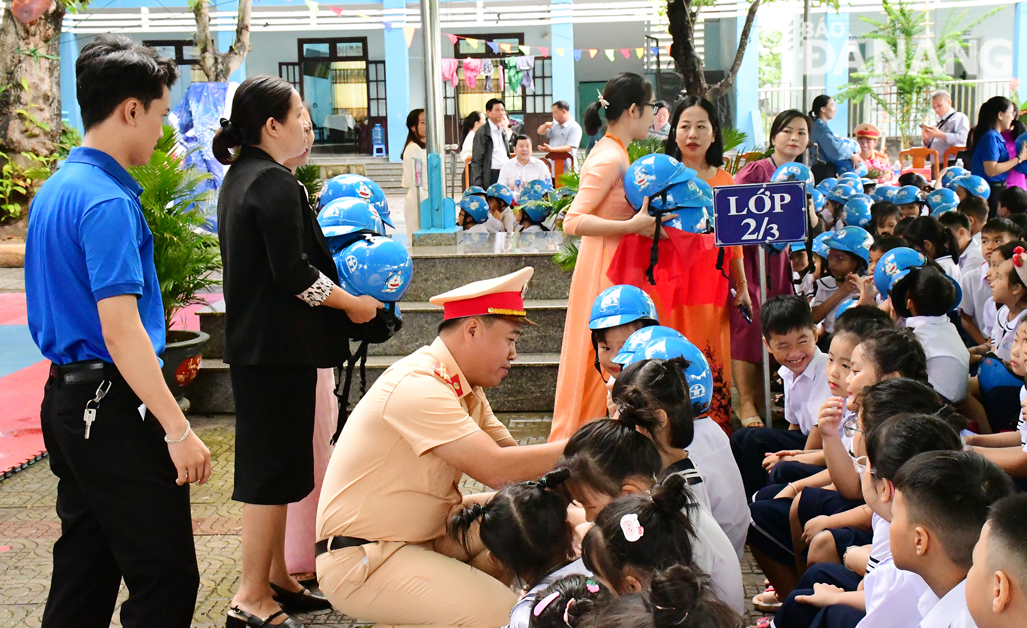 Lãnh đạo Phòng Cảnh sát giao thông, Công an thành phố đội mũ cho các cháu. Ảnh: THÀNH LÂN