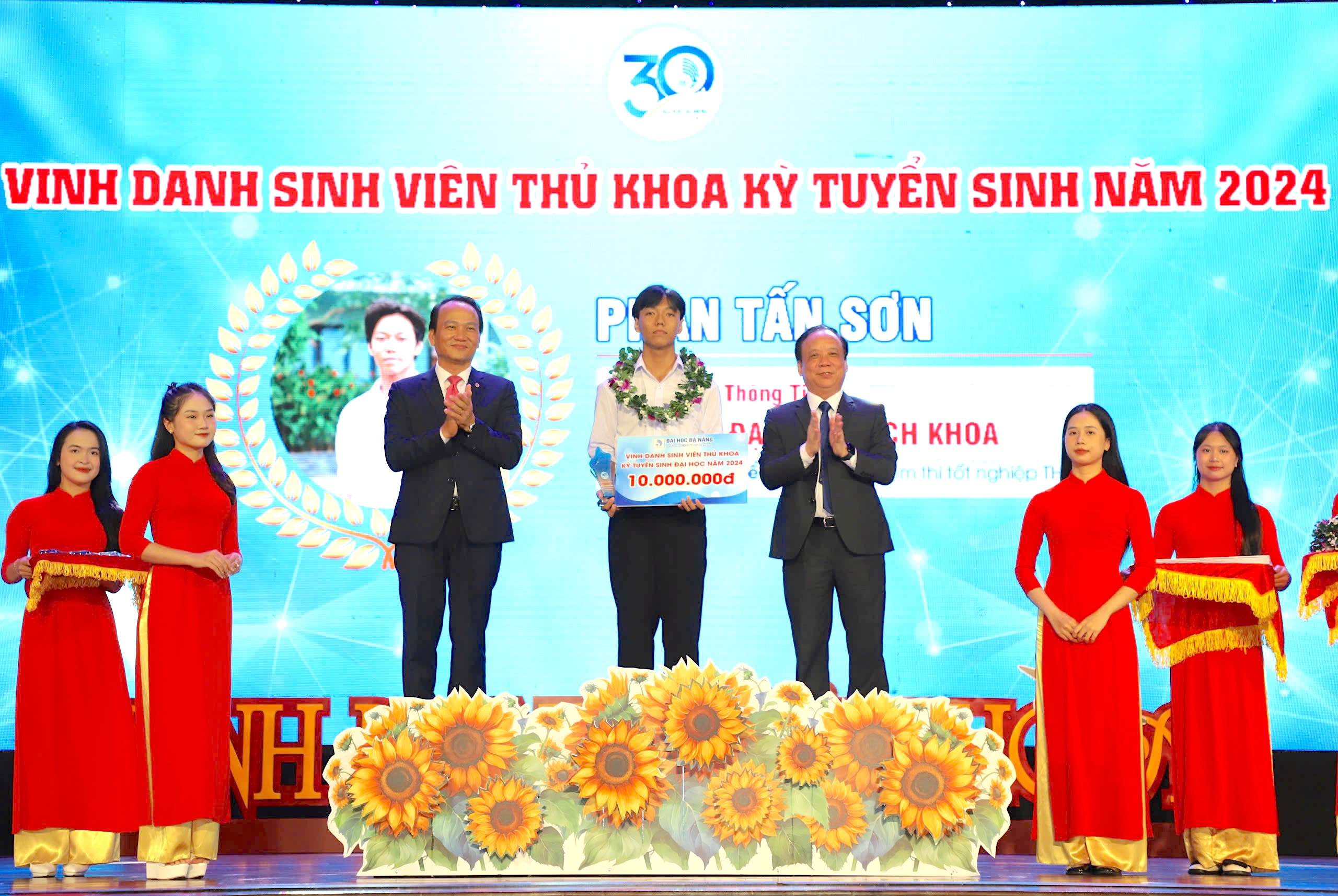 Standing Deputy Secretary of the Da Nang Party Committee Nguyen Dinh Vinh (left) and Director of the University of Da Nang Nguyen Ngoc Vu (right) awarding a prize to the top student of the entrance exam to the University of Science and Technology, the University of Da Nang for the 2024-2025 school year. Photo: NGOC HA