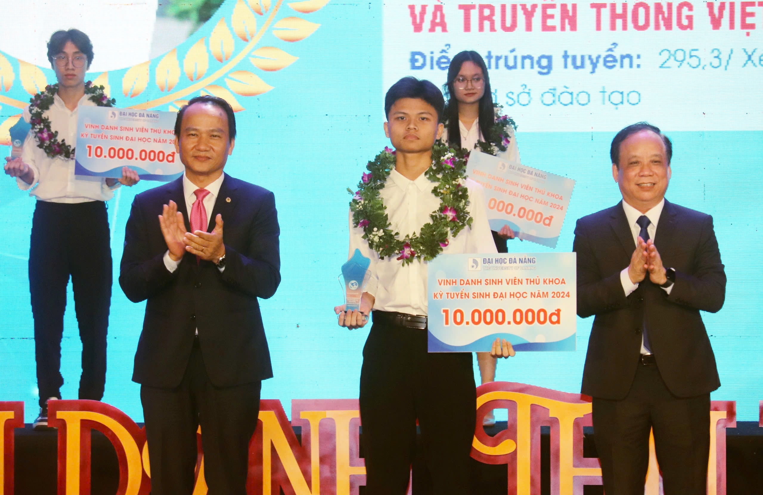 Standing Deputy Secretary of the Da Nang Party Committee Nguyen Dinh Vinh (left) and Director of the University of Da Nang Nguyen Ngoc Vu (right) awarding a prize to the top student of the university entrance exam in the 2024-2025 school year. Photo: NGOC HA