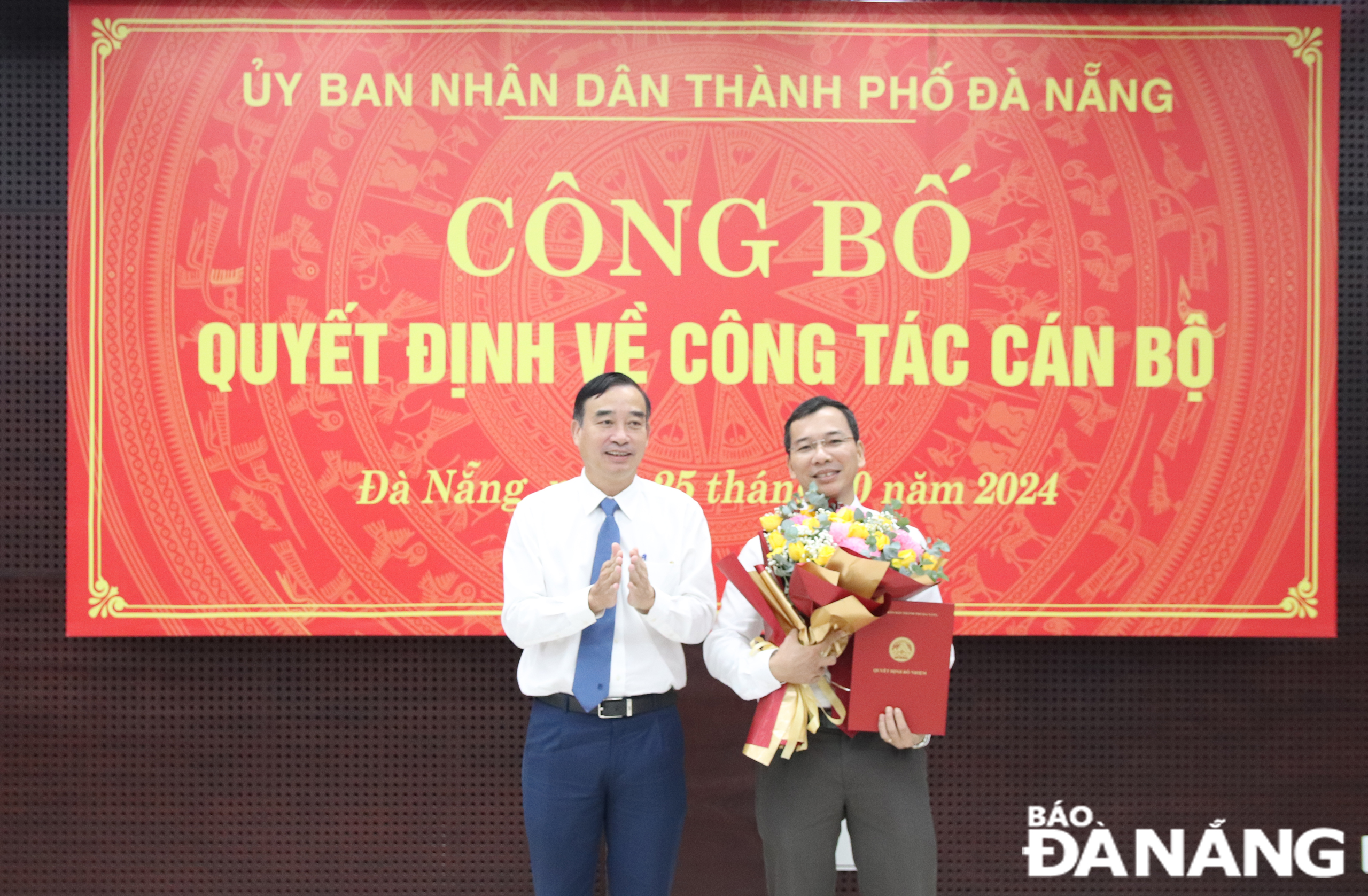 Chủ tịch UBND thành phố Lê Trung Chinh (trái) trao quyết định, tặng hoa chúc mừng tân Giám đốc Sở Nội vụ Nguyễn Hữu Lợi. Ảnh: TRỌNG HUY