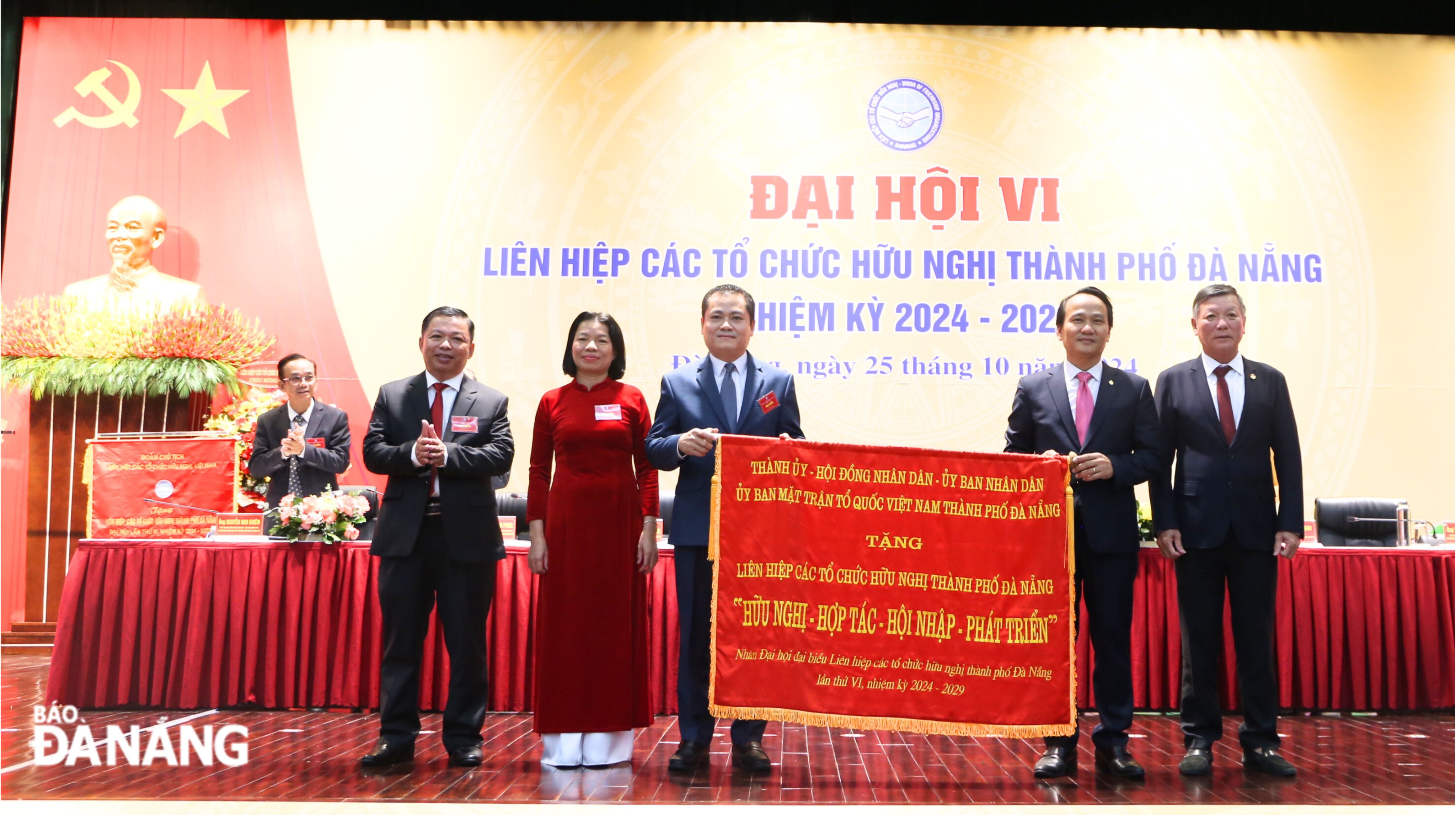 Phó Bí thư Thường trực Thành ủy Đà Nẵng Nguyễn Đình Vĩnh (thứ 2, bên phải sang), Chủ tịch Ủy ban MTTQ Việt Nam thành phố Lê Văn Trung (bìa phải) trao tặng bức trướng “Hữu nghị - Hợp tác - Hội nhập - Phát triển” cho đại hội. Ảnh: X.HẬU