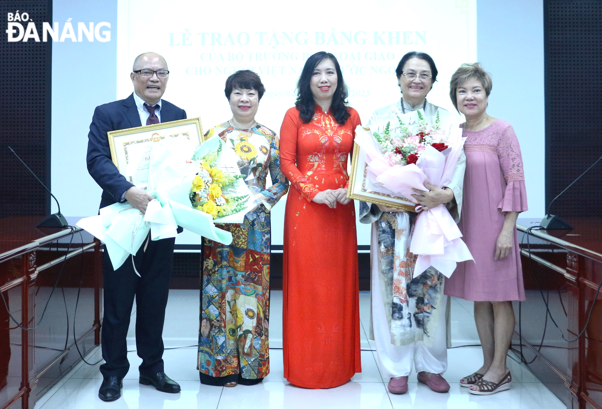 Deputy Minister of Foreign Affairs cum Chairwoman of the State Committee for Overseas Vietnamese Affairs Le Thi Thu Hang (middle) and Deputy Director of the Da Nang Department of Foreign Affairs Nguyen Thuy Anh (2nd, left) award the Minister of Foreign Affairs-granted certificates of merit to Ms. Cecile Le Pham (2nd, right) and Mr. Bao Hoa (left) for their many positive contributions to the city's socio-economic development in 2023. Photo: T. PHUONG