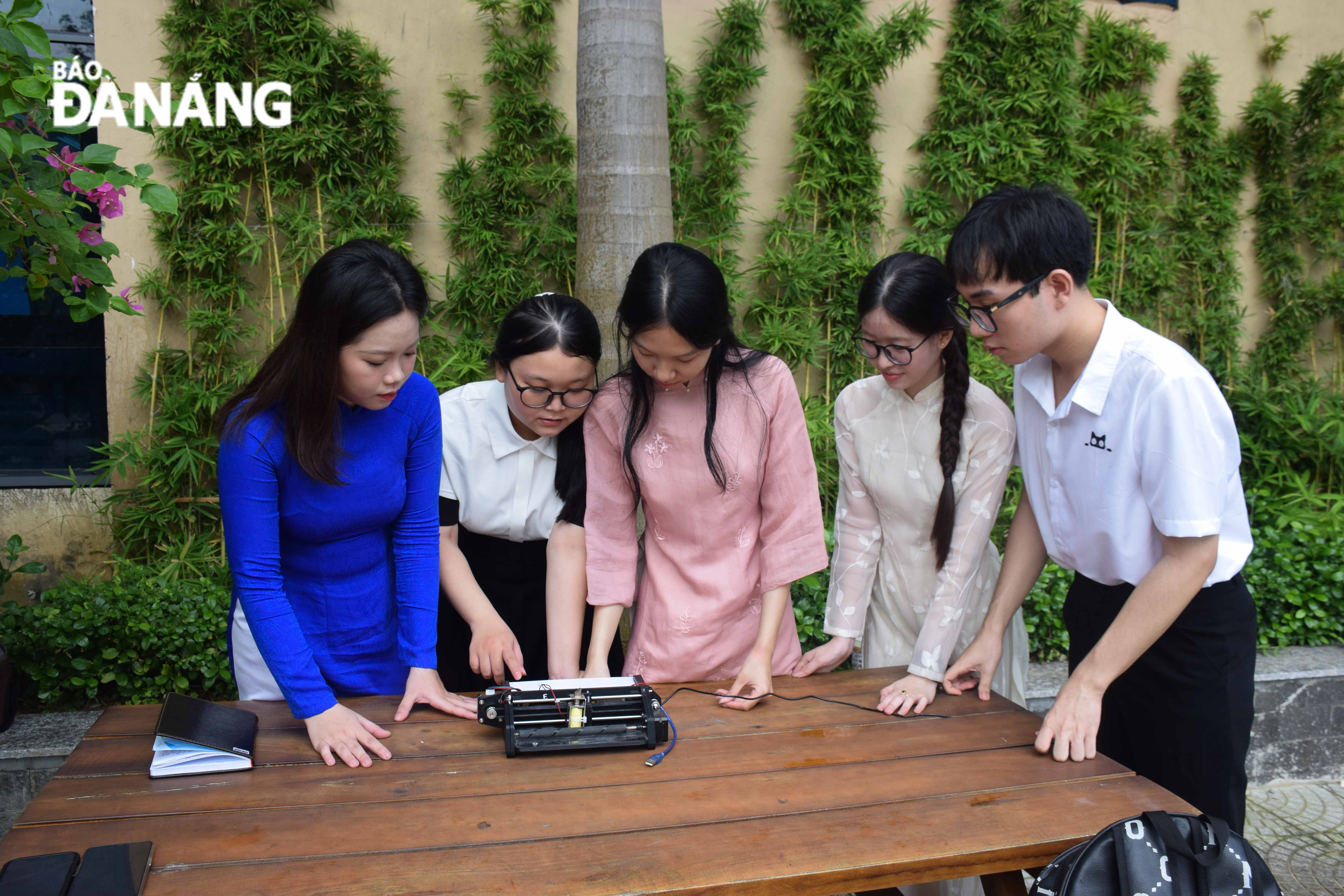 Student Le Thanh Truc and her research team recheck the operation of the Braille printer after it was created. Photo: D.H.L