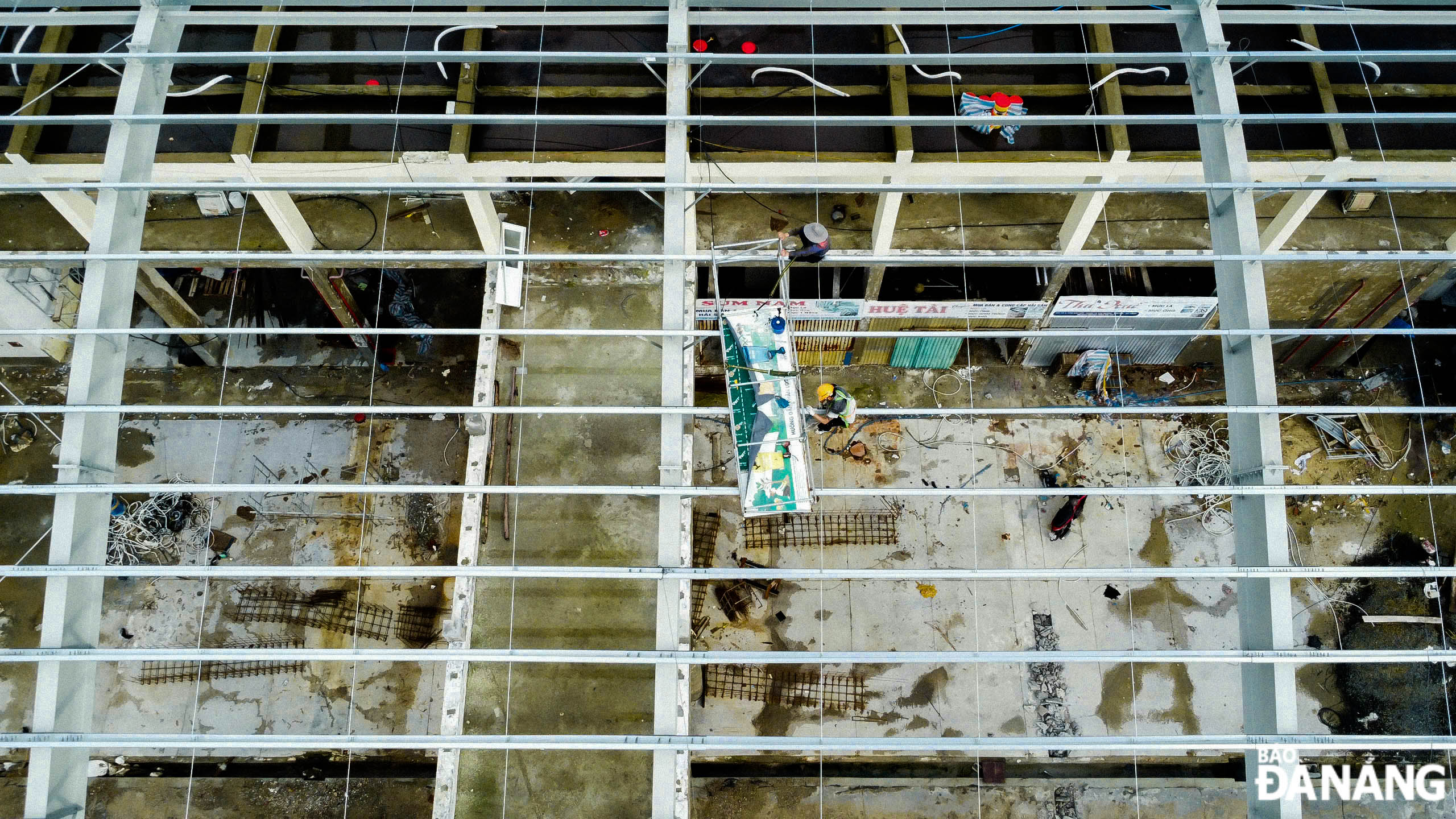 Workers are seen working hard at the construction site of the docks and seafood trading houses.