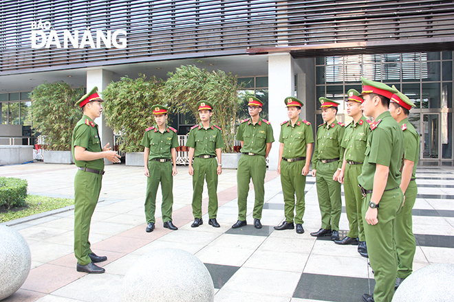 Thiếu tá Mai Tấn Phúc (bên trái) trao đổi nghiệp vụ với các chiến sĩ tham gia ca trực tại vọng gác mục tiêu Trung tâm Hành chính thành phố. Ảnh: XUÂN HẬU