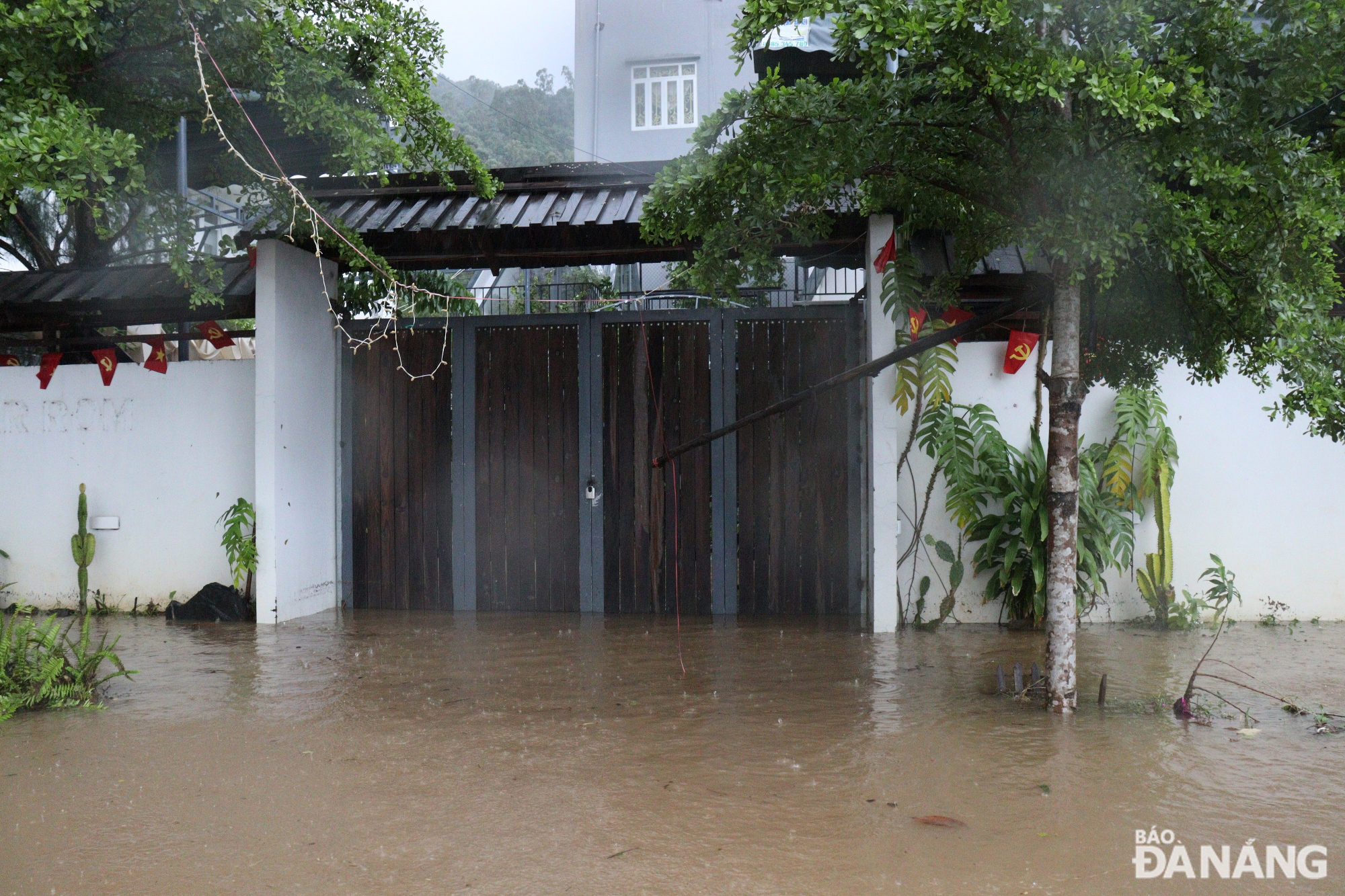 Nước mưa từ sườn núi đổ xuống gây ngập đường Lương Hữu Khánh và tràn vào nhà dân. Ảnh: HOÀNG HIỆP