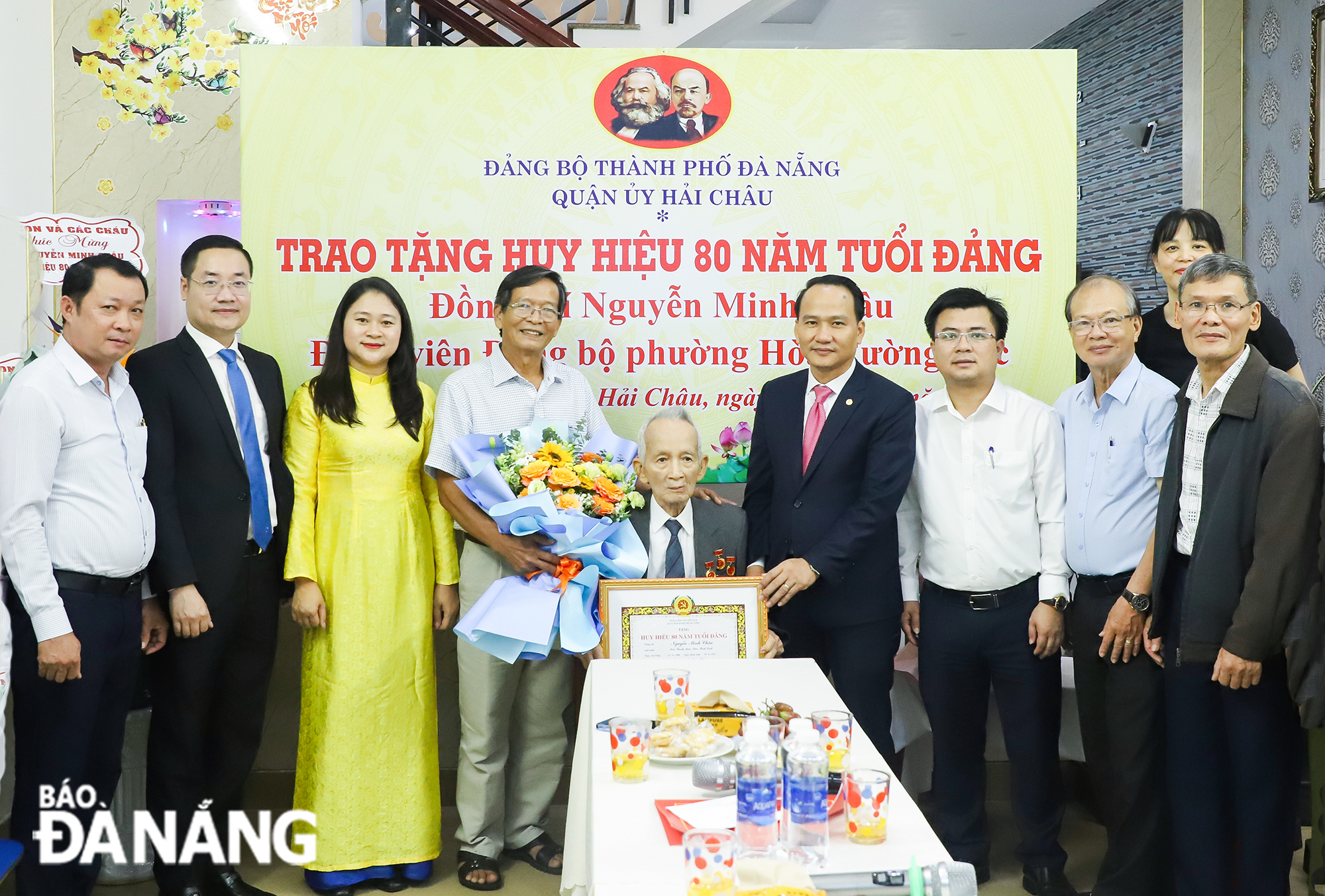 Phó Bí thư Thường trực Thành ủy Nguyễn Đình Vĩnh (   ) trao Huy hiệu 80 năm tuổi Đảng cho đảng viên Nguyễn Minh Châu. Ảnh: NGỌC PHÚ