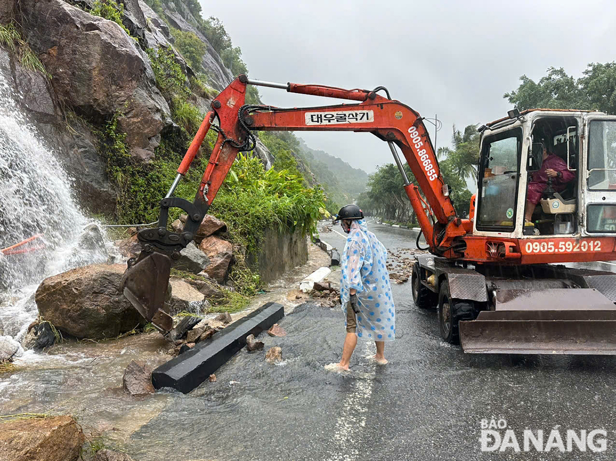 Soil and rocks spilled onto the road leading to the Son Tra Peninsula are cleaned up. Photo: THANH LAN