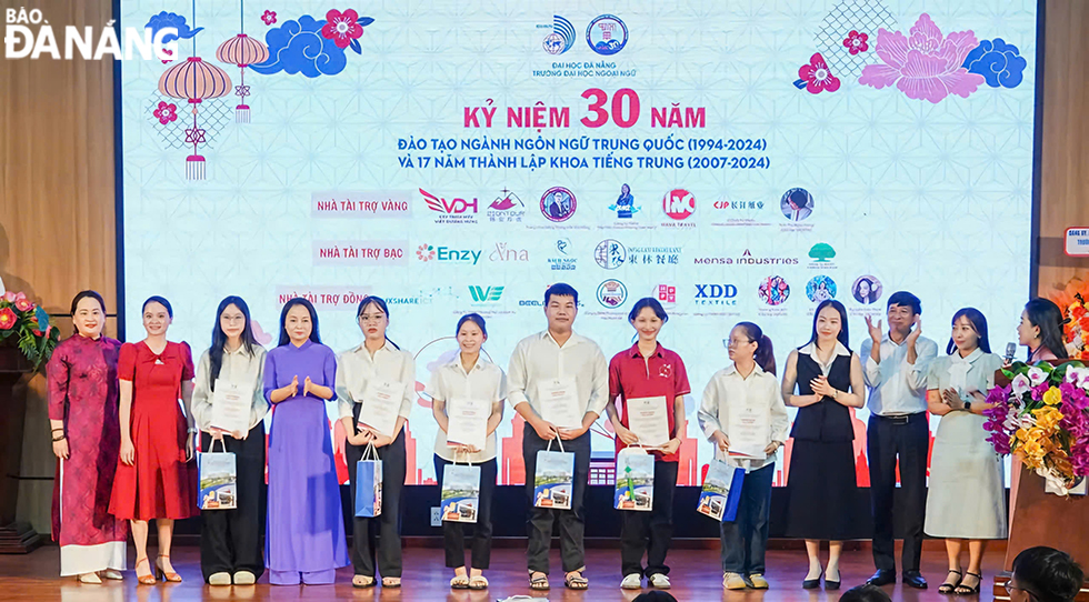 Trong lễ kỷ niệm 30 năm, đại diện Trường Đại học Ngoại ngữ, khoa tiếng trung, cựu sinh viên đã trao học bổng cho các sinh viên nghèo học giỏi. Ảnh: THU HÀ.