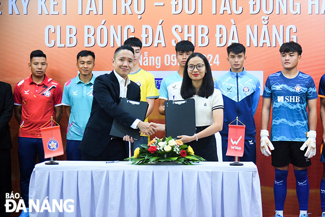 A representative of SHB Da Nang Club (left) signing a sponsorship contract with Wika