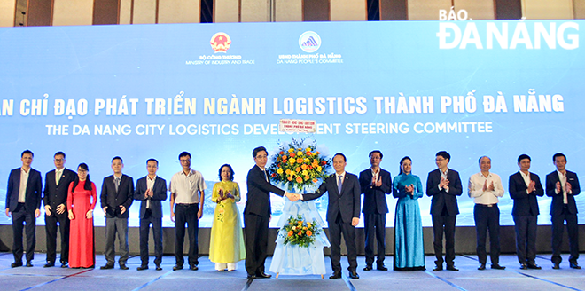 Standing Deputy Secretary of the Da Nang Party Committee Nguyen Dinh Vinh (7th, right) presents flowers to the Da Nang Logistics Development Steering Committee. Photo: MAI QUE - QUOC CUONG