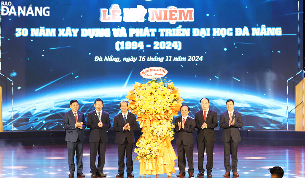 Minister of Education and Training Nguyen Kim Son (left, third), presented flowers to congratulate UDN's leadership team. Photo: THU HA