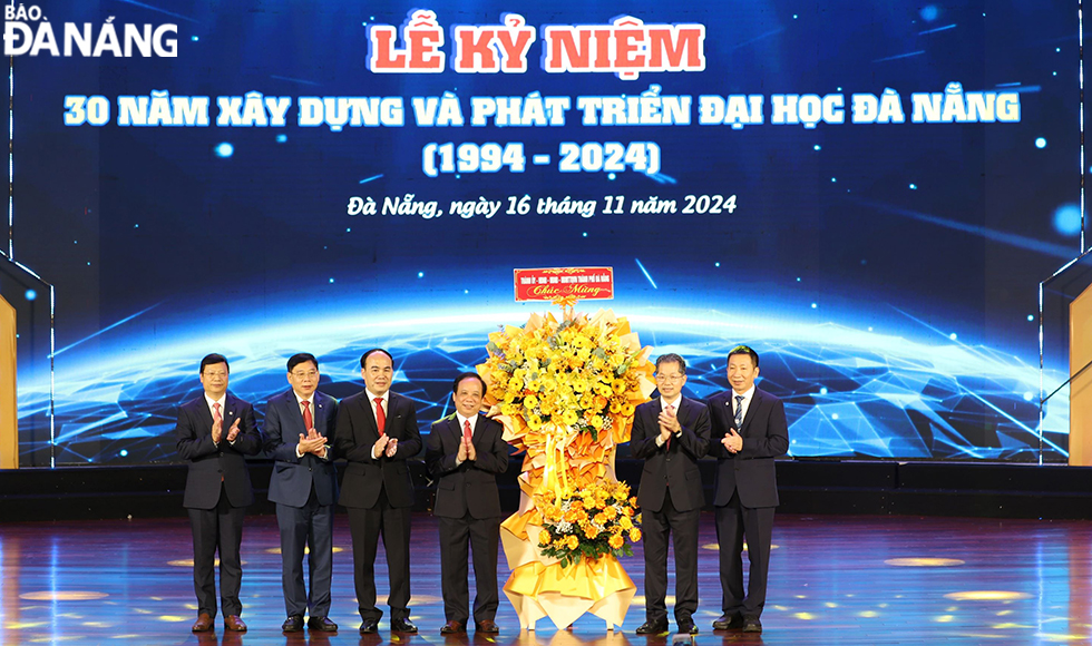 Da Nang Party Committee Secretary Nguyen Van Quang (right, second) extended his congratulations with flowers to the university’s representatives. Photo: THU HA