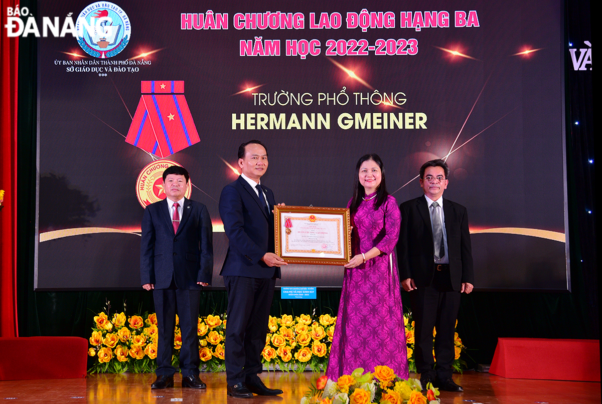 Standing Deputy Secretary of the municipal Party Committee Nguyen Dinh Vinh (front row, left) awarding the Third-class Labour Medal to the Da Nang Hermann Gmeiner High School.