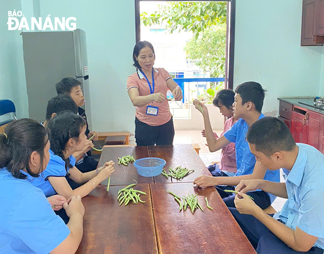 Ms. Ngan teaches life skills to disabled children. Photo: LINH DAN