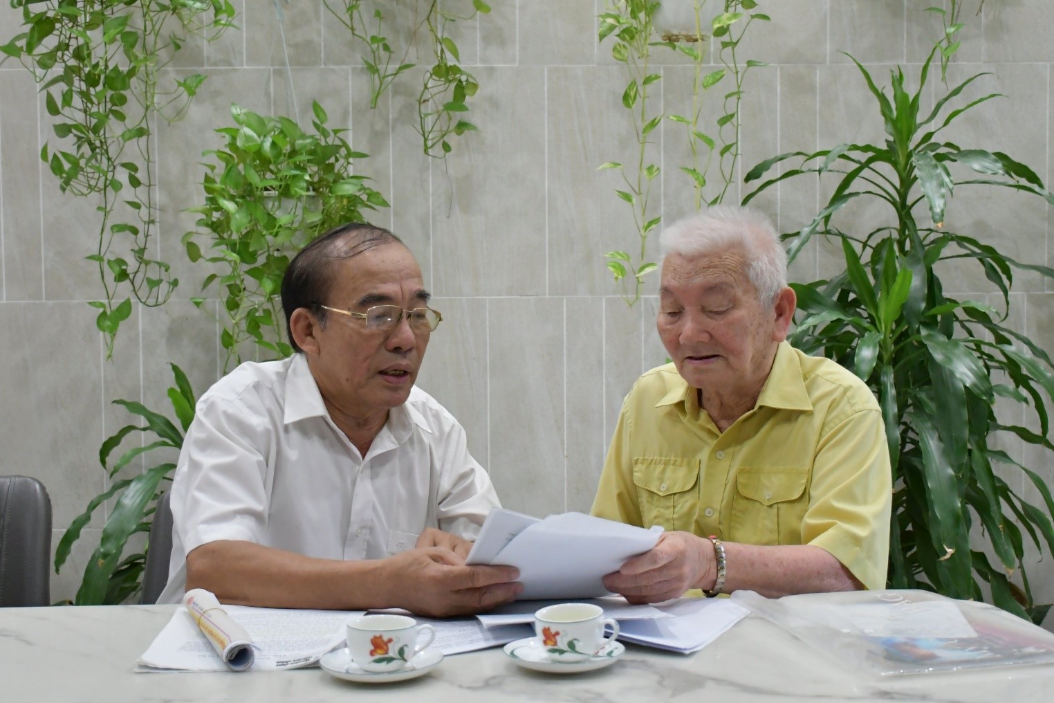 Captain of the unnumbered ship, Vu Tan Ich (right), discussing with Colonel Phan Van Cuc some historical documents about the Ho Chi Minh trail at sea. Photo: T.Y.