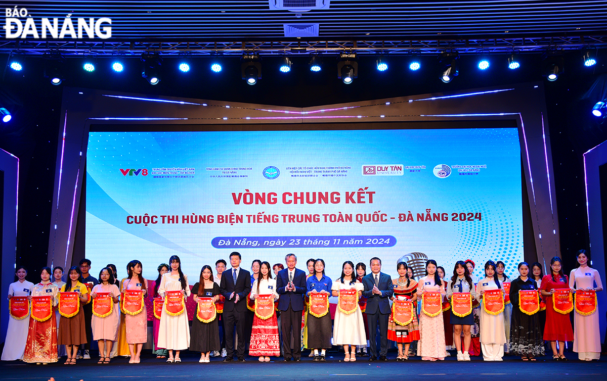 Head of the Da Nang Party Committee's Publicity and Training Department Doan Ngoc Hung Anh (9th, front row, right) presenting souvenir flags to contestants in the final round. Photo: X.D