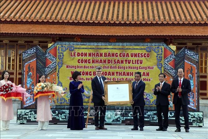 Trưởng Đại diện Văn phòng UNESCO tại Việt Nam Jonathan Wallace Baker trao Bằng công nhận di sản tư liệu khu vực châu Á - Thái Bình Dương của UNESCO đối với “Những bản đúc nổi trên chín đỉnh đồng ở Hoàng cung Huế” cho phía Việt Nam. Ảnh: Đỗ Trưởng/TTXVN