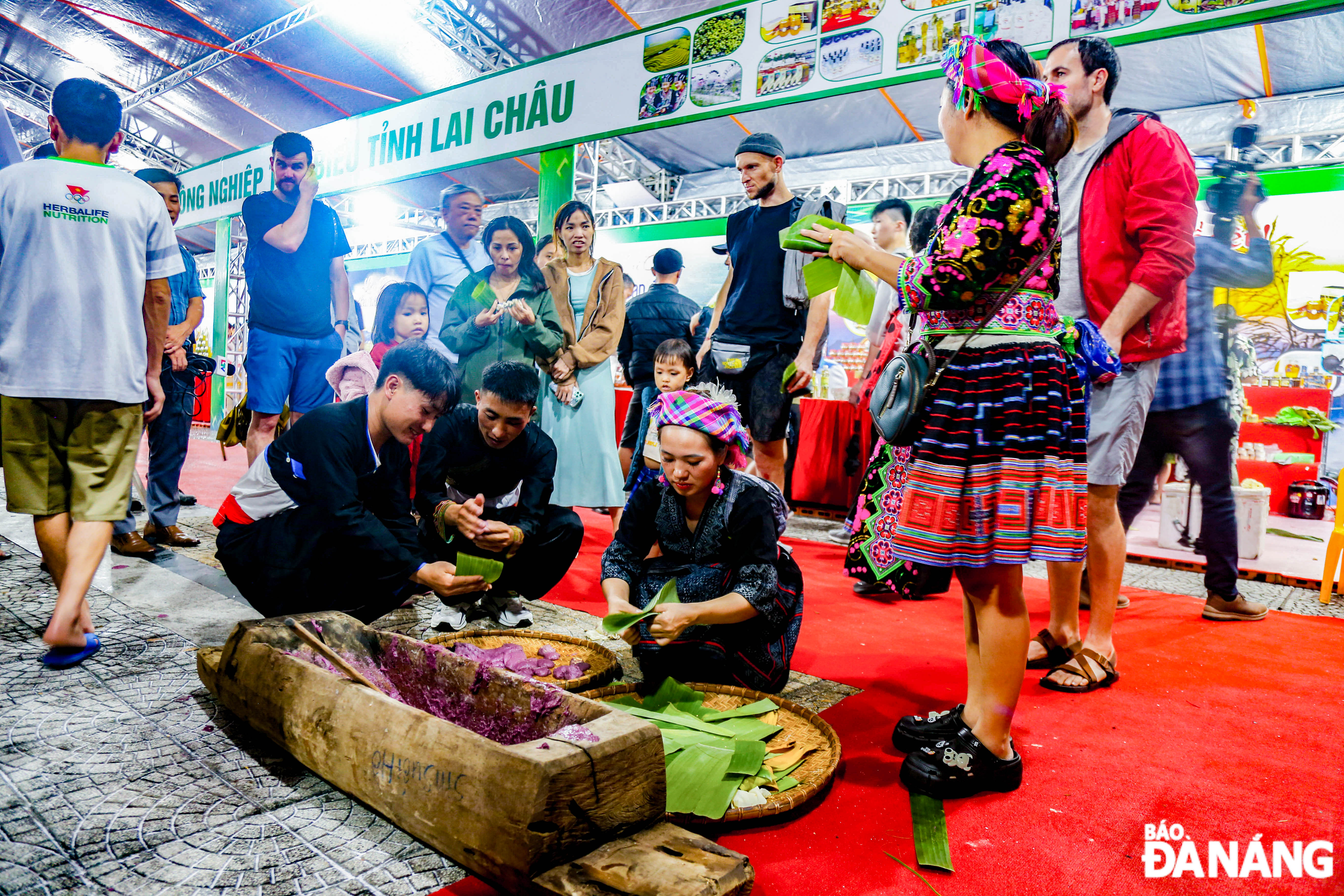 Pounding bánh dày (round glutinous rice cake) and inviting visitors to enjoy the dish directly at the programme.